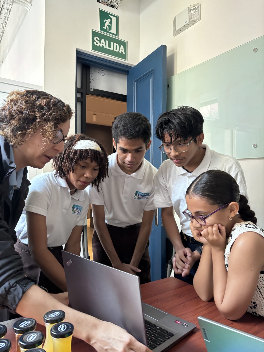 Students collaborating around a laptop